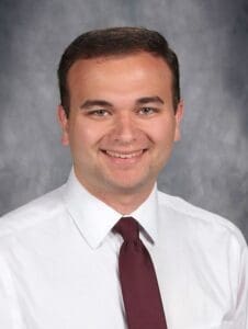 A man in white shirt and red tie.