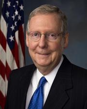 A man in suit and tie next to an american flag.